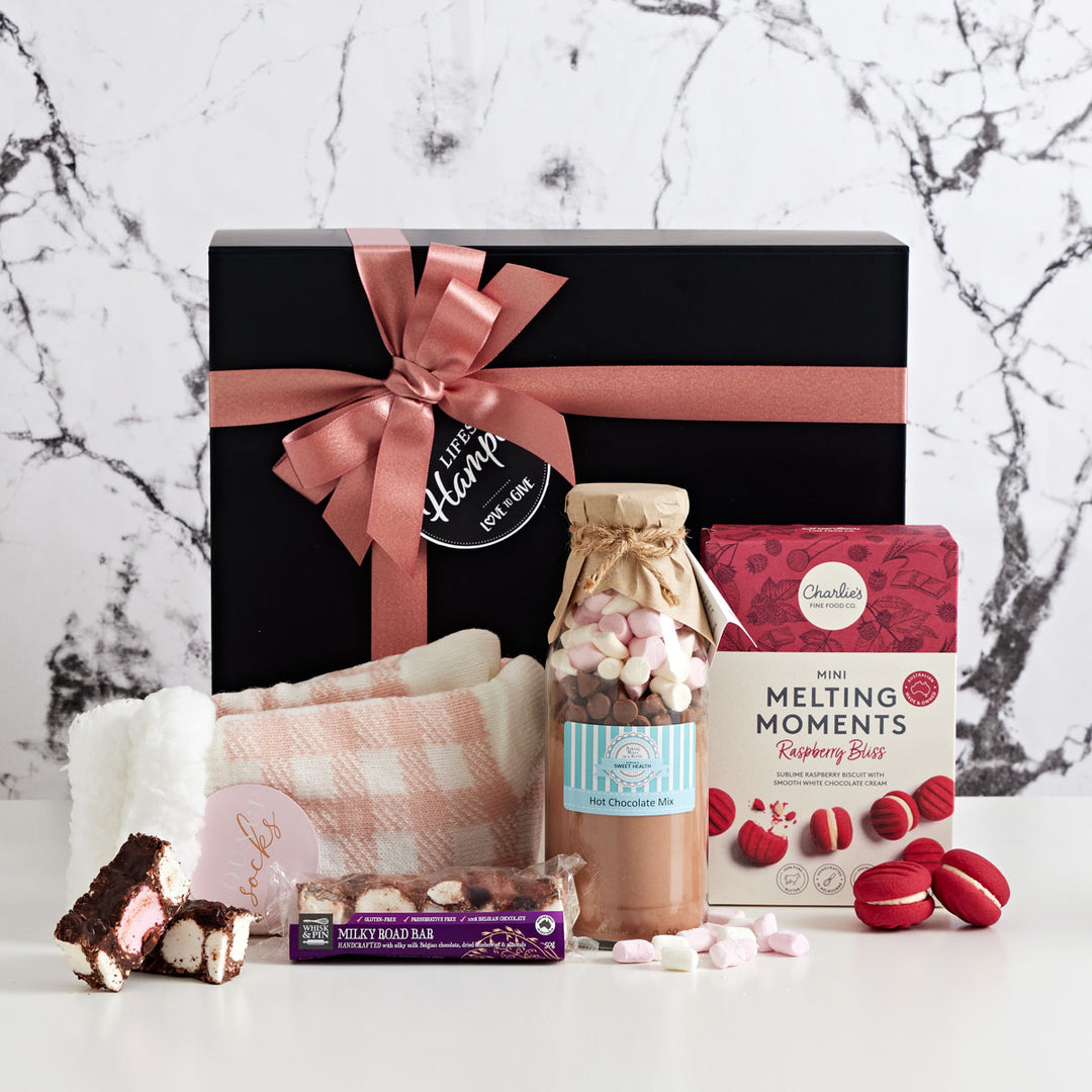 Sweet Comfort Hamper is an ideal get well soon gift hamper. It comes with pink gingham lounge socks, Raspberry bliss melting moments. sweet health hot chocolate and whisk & pin milky rocky road.