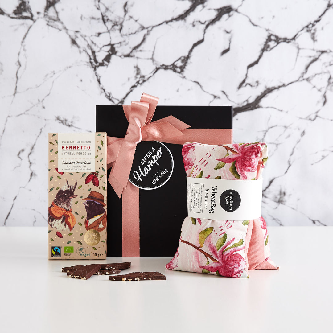 Time Out Gift Hamper comes in a black box with pink ribbon. It's a simple yet stylish gift hamper and includes a wheat bag by wheatbags love and a bennetto natural foods company toasted hazelnut chocolate. This gift it the perfect gift to send a friend to say I'm Thinking of You or R U OK?