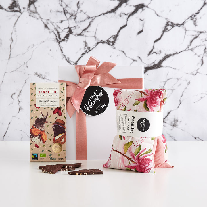 Time Out Gift Hamper comes with a white box with a luxurious pink ribbon. Inside this stylish gift hamper comes a lavender scented wheat bag by wheatbags love and a bennetto natural foods company chocolate hazelnut bar. The perfect get well soon gift hamper